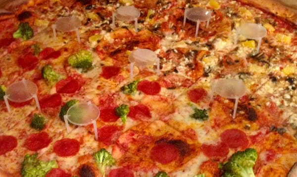 a pizza that may or may not look enormous, depending on the scale. the image is cropped close so only glimpses of the pizza b