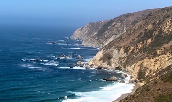 a desert landscape meeting a vast blue ocean