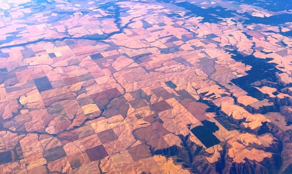 squares of farmland in central idaho as seen from a plane