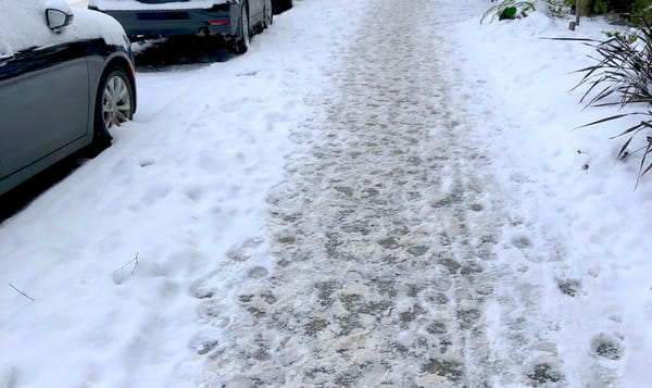 footprints in the snow on a city sidewalk