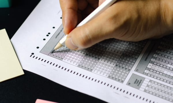 a person's hand filling out an exam