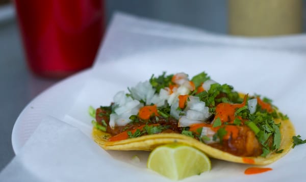 taco on a plate topped with bright orange salsa