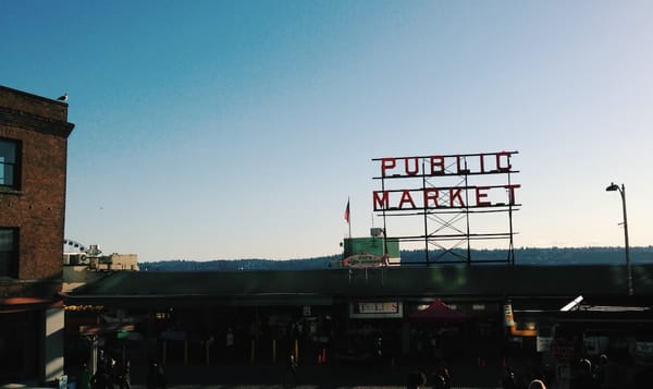 a daytime photo of the pike place market sign with a filter on it