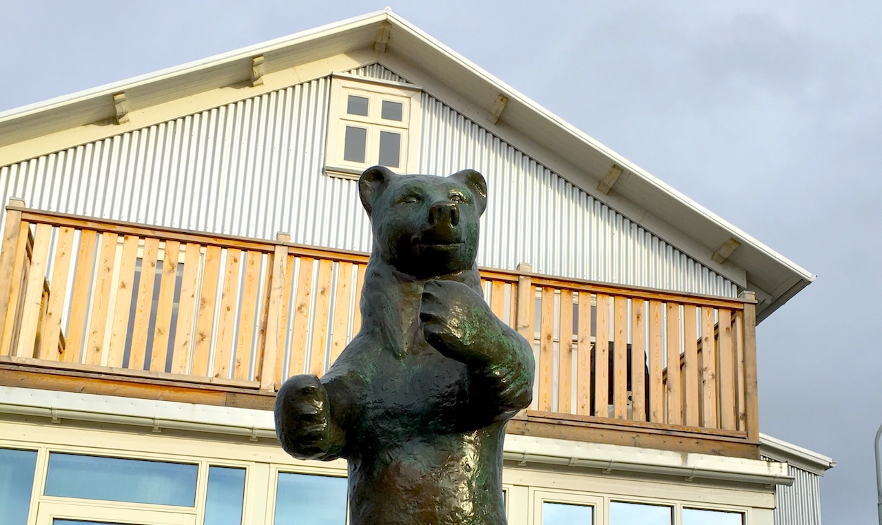 a metal statue of a bear standing outside a building in Reykjavík. 