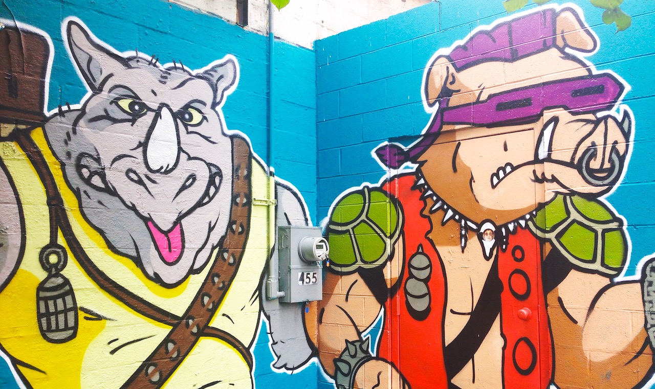 a mural of a humanoid rhinocerous and warthog, dressed in street clothing