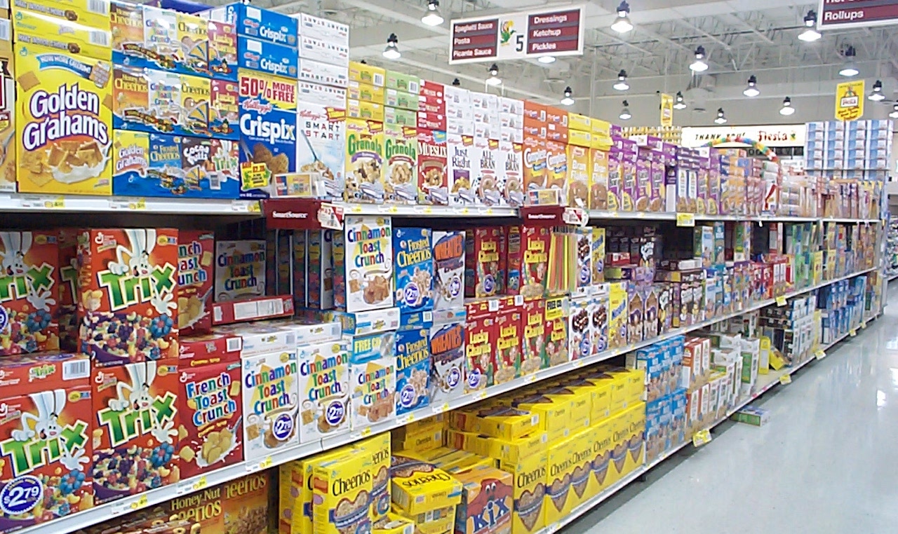 a photo of a grocery store aisle of boxed cereals, stretching from one end of the photo to another.