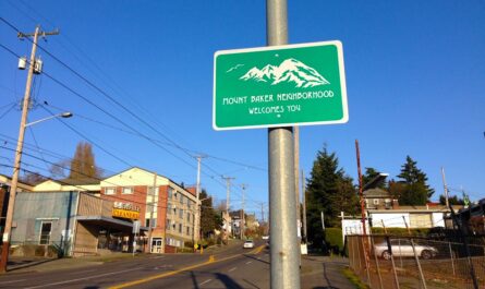a green sign that reads "mount baker neighborhood welcomes you" overlooking the neighborhood of the same name