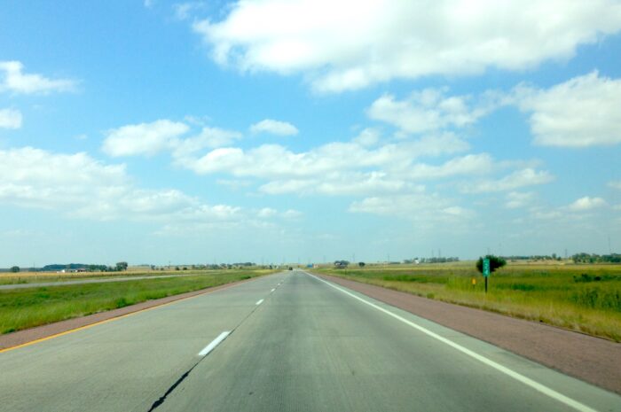 a two-lane road that leads across the plains