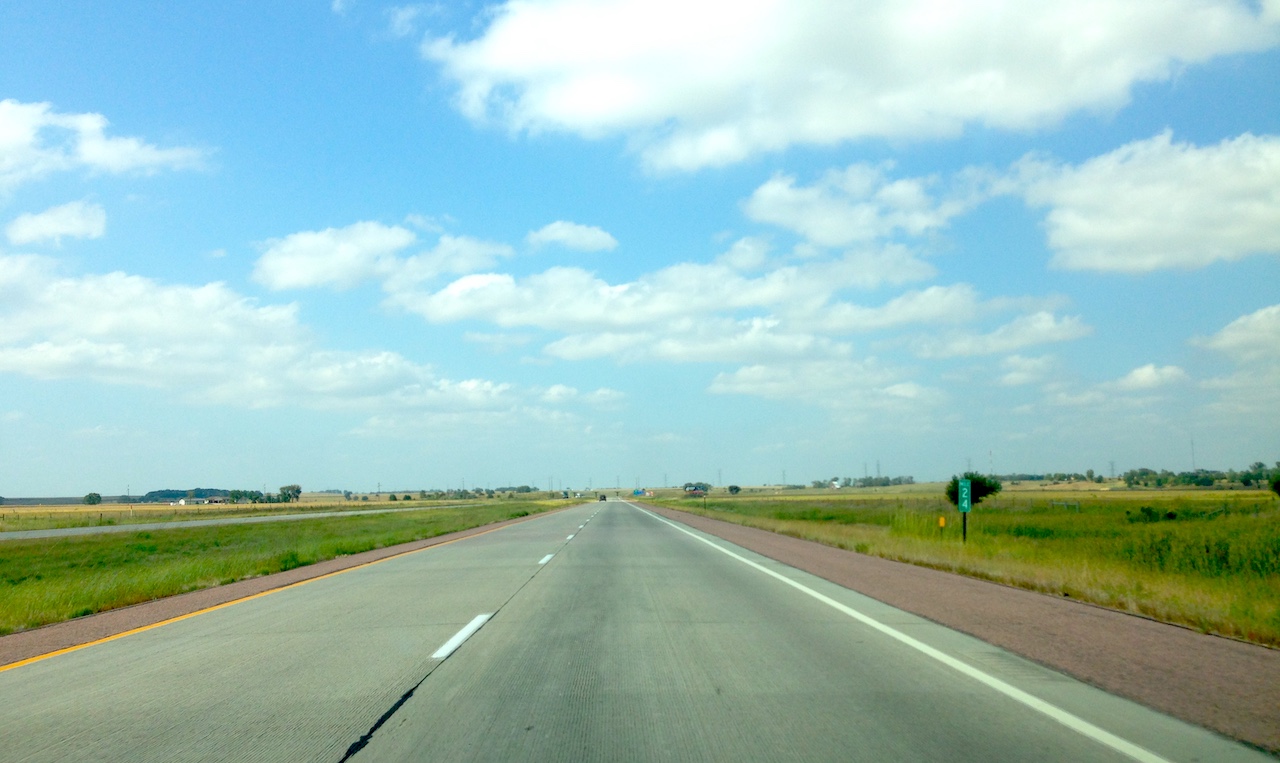 a two-lane road that leads across the plains