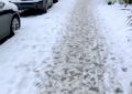 footprints in the snow on a city sidewalk
