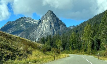a winding road passes in front of a large granite mountain outside snoqualmie pass